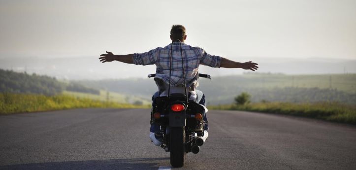 Caucasian-man-riding-motorcycle-with-arms-outstretched.jpg